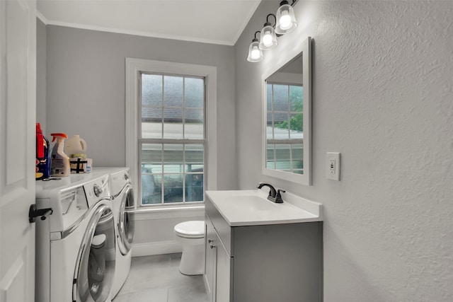 1316 Elm St, Bonham, TX 75418 - bathroom featuring independent washer and dryer, toilet, vanity, ornamental molding, and tile patterned flooring