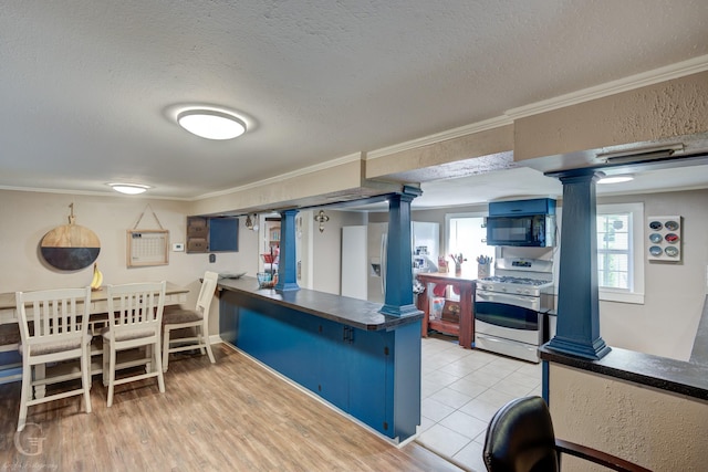 198 Main St, Doyline, LA 71023 - kitchen featuring gas range oven, decorative columns, black microwave, crown molding, and a textured ceiling
