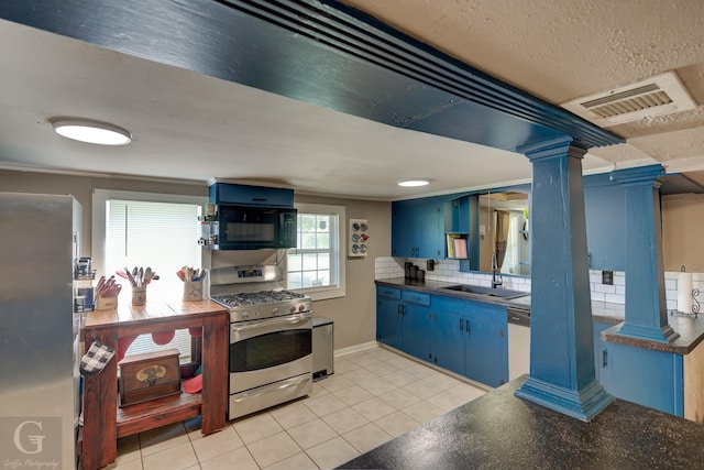 198 Main St, Doyline, LA 71023 - kitchen with blue cabinets, stainless steel appliances, dark countertops, ornate columns, and a textured ceiling