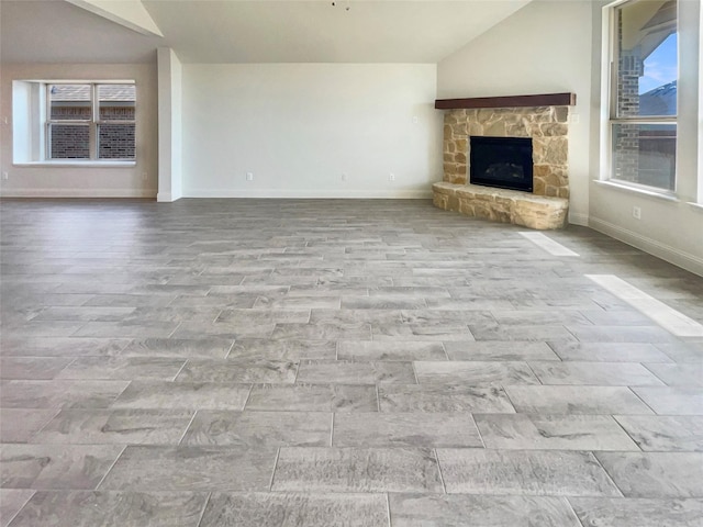 629 Brody Trl, Aledo, TX 76008 - unfurnished living room with lofted ceiling, a stone fireplace, and baseboards