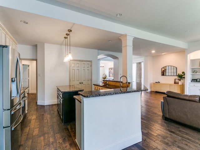 2270 Magic Mantle Dr, Lewisville, TX 75056 - kitchen featuring stainless steel fridge, dark wood finished floors, dark stone countertops, open floor plan, and arched walkways