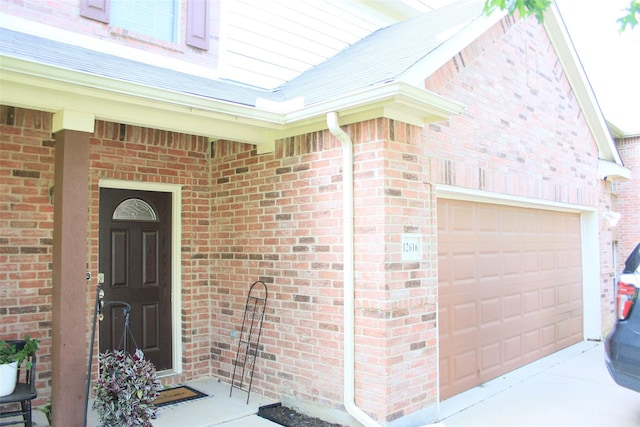 12616 Viewpoint Ln, Fort Worth, TX 76028 - doorway to property featuring a garage, brick siding, and driveway