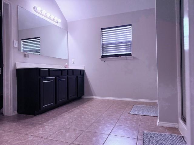 12616 Viewpoint Ln, Fort Worth, TX 76028 - full bathroom featuring vanity, vaulted ceiling, tile patterned floors, baseboards, and an enclosed shower