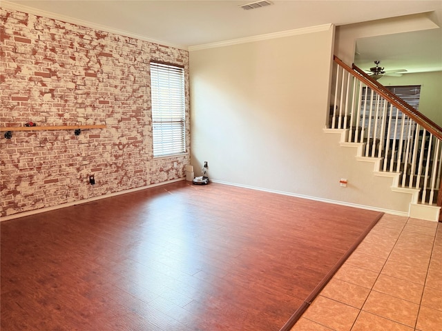 12616 Viewpoint Ln, Fort Worth, TX 76028 - unfurnished living room with baseboards, brick wall, crown molding, ceiling fan, and stairway