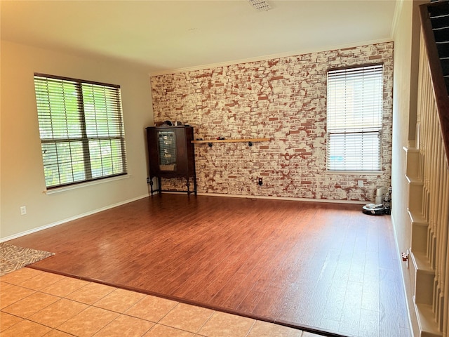 12616 Viewpoint Ln, Fort Worth, TX 76028 - unfurnished living room with wood finished floors, brick wall, baseboards, and crown molding
