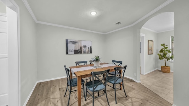 104 Shadowoak Ct, Burleson, TX 76028 - dining space featuring arched walkways, ornamental molding, light wood-style floors, and baseboards