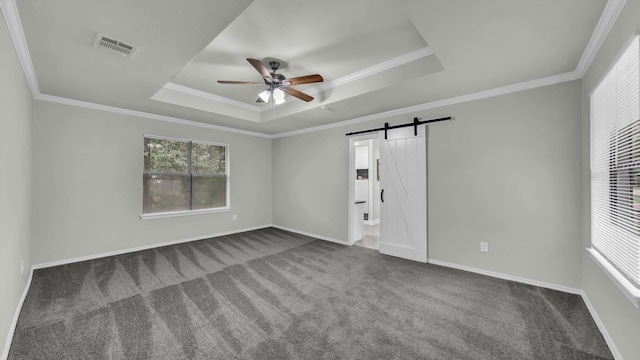 104 Shadowoak Ct, Burleson, TX 76028 - spare room featuring a barn door, a tray ceiling, dark colored carpet, and ornamental molding