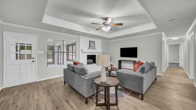 104 Shadowoak Ct, Burleson, TX 76028 - living room featuring a tray ceiling, wood finished floors, a fireplace, ceiling fan, and baseboards