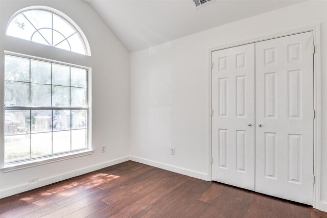 7405 Armstrong Ln, Rowlett, TX 75089 - unfurnished bedroom with dark wood-style floors, vaulted ceiling, a closet, and baseboards