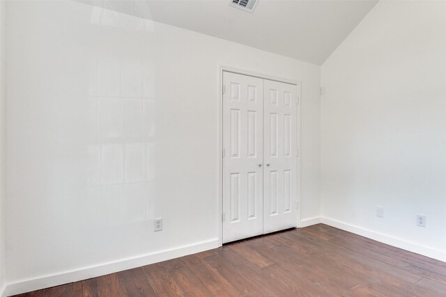 7405 Armstrong Ln, Rowlett, TX 75089 - unfurnished bedroom with dark wood-style floors, a closet, baseboards, and lofted ceiling