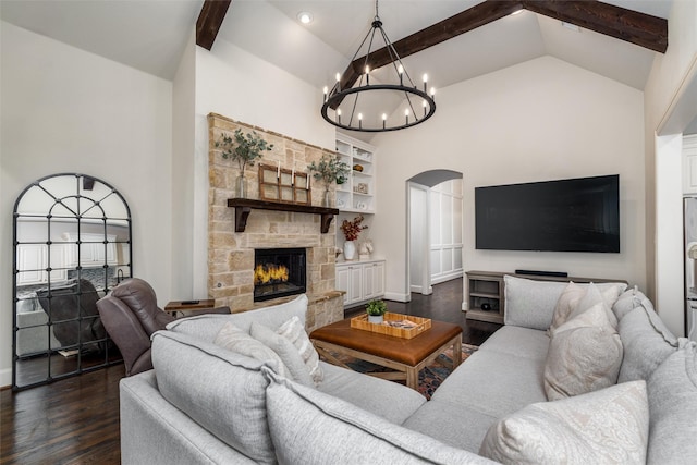 321 Hitch Wagon Dr, Mckinney, TX 75071 - living area featuring a chandelier, dark wood-style flooring, beam ceiling, a stone fireplace, and arched walkways