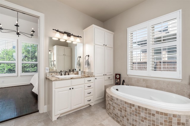 321 Hitch Wagon Dr, Mckinney, TX 75071 - bathroom featuring a garden tub, vanity, a chandelier, and tile patterned flooring