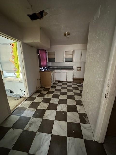 2915 56th St, Dallas, TX 75241 - kitchen featuring white cabinets, dark countertops, and light flooring
