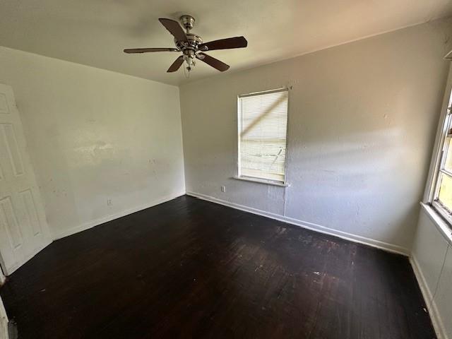 2915 56th St, Dallas, TX 75241 - empty room featuring dark wood-style flooring, a ceiling fan, and baseboards