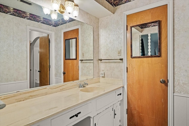3601 University Dr, Garland, TX 75043 - bathroom with vanity, a chandelier, and wallpapered walls