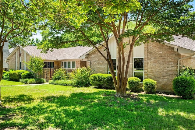 3601 University Dr, Garland, TX 75043 - view of front of house with brick siding, a front lawn, and roof with shingles
