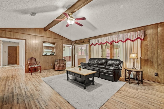3601 University Dr, Garland, TX 75043 - living room with wooden walls, a ceiling fan, wood finished floors, and a textured ceiling