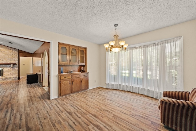 3601 University Dr, Garland, TX 75043 - dining room featuring a chandelier, light wood-style floors, and a textured ceiling