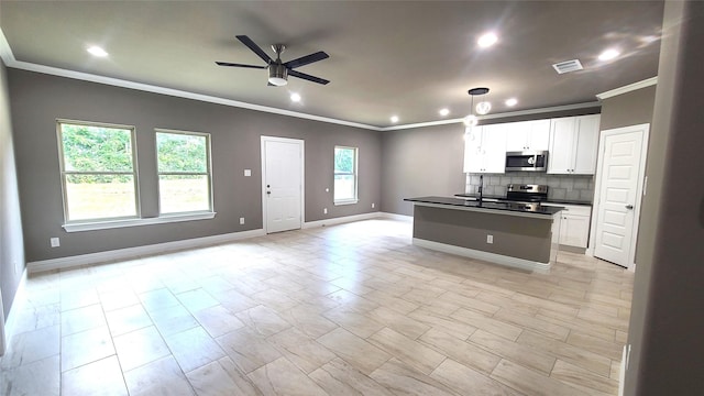 1820 Smoke Tree Ln, Dallas, TX 75253 - kitchen with stainless steel appliances, open floor plan, ornamental molding, ceiling fan, and dark countertops