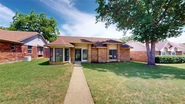 2605 Strother Dr, Garland, TX 75044 - view of front of home with cooling unit, a front lawn, brick siding, and roof with shingles