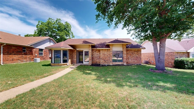 2605 Strother Dr, Garland, TX 75044 - view of front of house featuring a front yard, brick siding, and central AC unit
