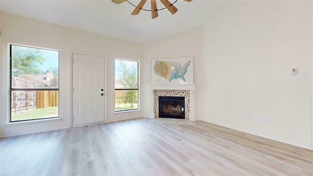 2605 Strother Dr, Garland, TX 75044 - unfurnished living room with light wood-style flooring, ceiling fan, a tile fireplace, vaulted ceiling, and baseboards