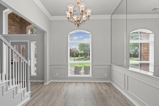 9117 Roundbluff Rd, Plano, TX 75025 - unfurnished dining area with a chandelier, light wood finished floors, healthy amount of natural light, ornamental molding, and wainscoting