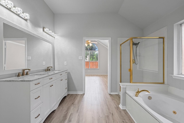 9117 Roundbluff Rd, Plano, TX 75025 - bathroom with double vanity, wood finished floors, a tub with jets, a shower stall, and vaulted ceiling
