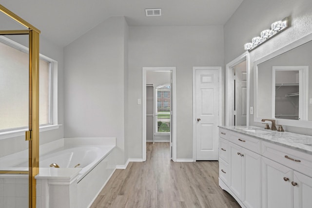 9117 Roundbluff Rd, Plano, TX 75025 - bathroom featuring healthy amount of natural light, vanity, a bath, and wood finished floors