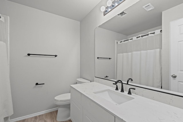 9117 Roundbluff Rd, Plano, TX 75025 - bathroom with toilet, vanity, wood finished floors, baseboards, and a shower with curtain