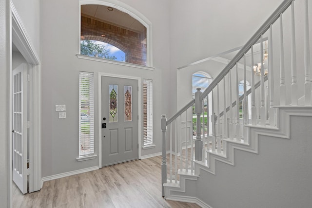 9117 Roundbluff Rd, Plano, TX 75025 - foyer entrance featuring stairway, a towering ceiling, wood finished floors, and baseboards
