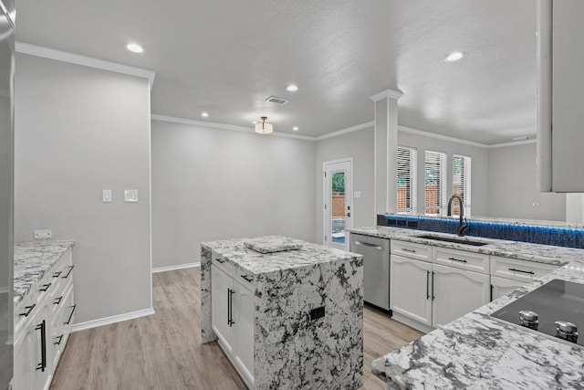 9117 Roundbluff Rd, Plano, TX 75025 - kitchen with stainless steel dishwasher, a sink, black electric stovetop, light wood-style flooring, and a kitchen island