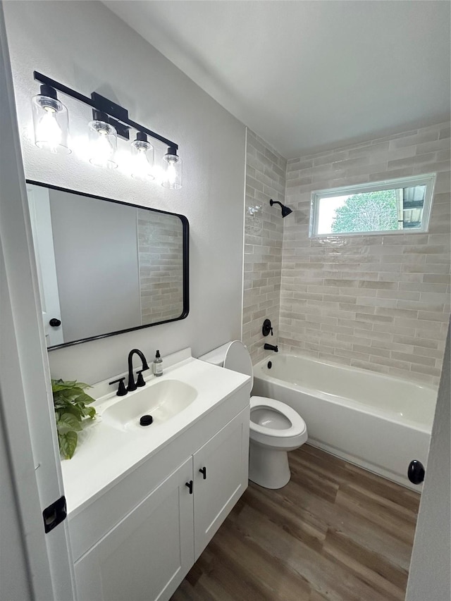 4423 Harvey Dr, Mesquite, TX 75150 - full bathroom featuring wood finished floors, vanity, toilet, and washtub / shower combination