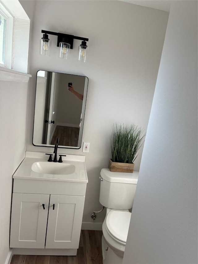 4423 Harvey Dr, Mesquite, TX 75150 - bathroom featuring wood finished floors, toilet, vanity, and baseboards
