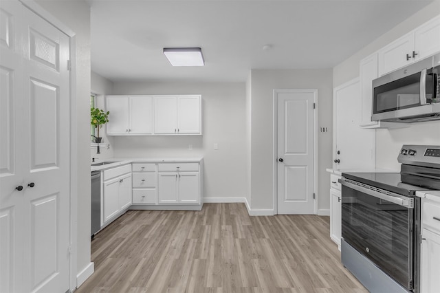 4423 Harvey Dr, Mesquite, TX 75150 - kitchen with stainless steel appliances, light wood-type flooring, light countertops, baseboards, and white cabinetry