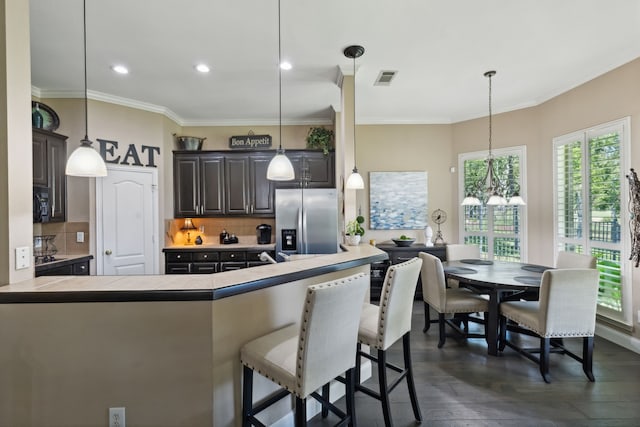 5516 Greenview Ct, North Richland Hills, TX 76148 - kitchen featuring stainless steel fridge with ice dispenser, a breakfast bar area, tasteful backsplash, ornamental molding, and dark wood-type flooring