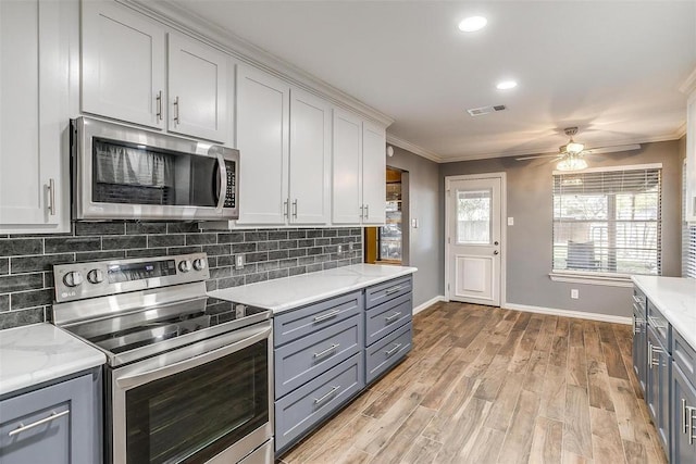 4428 Aspen Way, Haltom City, TX 76137 - kitchen with appliances with stainless steel finishes, gray cabinetry, ornamental molding, baseboards, and ceiling fan