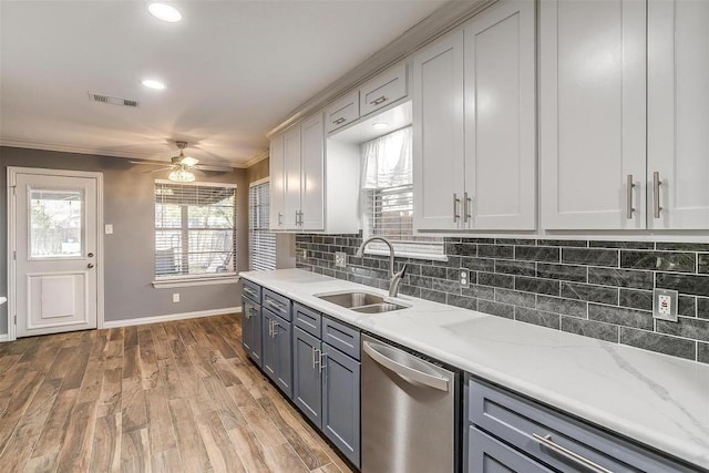 4428 Aspen Way, Haltom City, TX 76137 - kitchen with stainless steel dishwasher, a sink, crown molding, gray cabinets, and baseboards