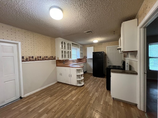 3304 Fadal Ave, Waco, TX 76708 - kitchen featuring wallpapered walls, black appliances, white cabinets, a textured ceiling, and dark countertops