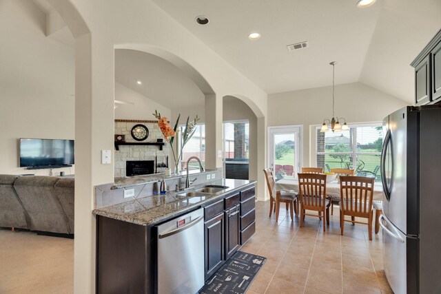 136 Devonshire Dr, Waxahachie, TX 75167 - kitchen with appliances with stainless steel finishes, a sink, lofted ceiling, open floor plan, and a fireplace