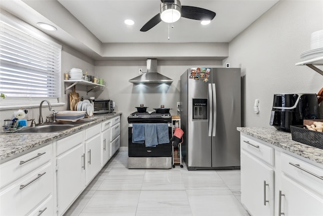 420 Shady Oaks Ln, Paris, TX 75460 - kitchen with stainless steel appliances, wall chimney range hood, a sink, ceiling fan, and white cabinets