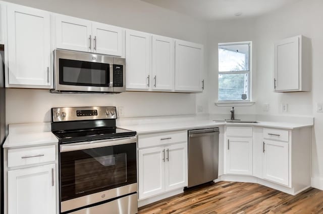 5105 Vandelia St, Dallas, TX 75235 - kitchen featuring appliances with stainless steel finishes, a sink, white cabinetry, light countertops, and light wood finished floors
