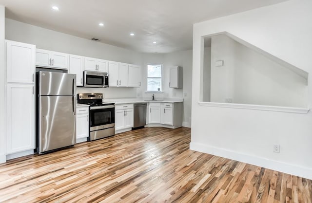 5105 Vandelia St, Dallas, TX 75235 - kitchen featuring appliances with stainless steel finishes, a sink, recessed lighting, light wood-type flooring, and light countertops