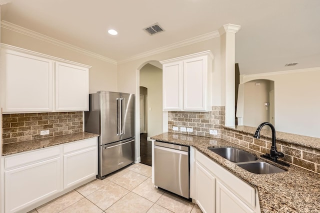 1017 Oarlock Dr, Crowley, TX 76036 - kitchen featuring appliances with stainless steel finishes, a sink, arched walkways, backsplash, and crown molding