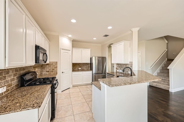 1017 Oarlock Dr, Crowley, TX 76036 - kitchen featuring black appliances, a peninsula, a sink, ornamental molding, and tasteful backsplash