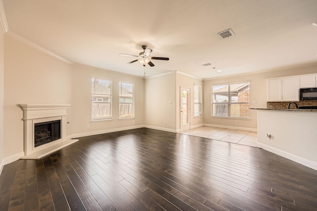 1017 Oarlock Dr, Crowley, TX 76036 - unfurnished living room with ceiling fan, ornamental molding, a fireplace with raised hearth, baseboards, and wood finished floors