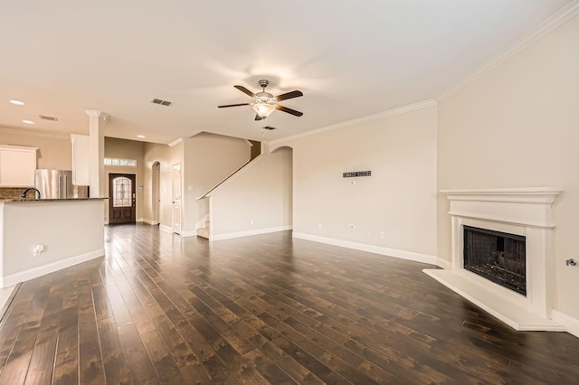 1017 Oarlock Dr, Crowley, TX 76036 - unfurnished living room featuring ceiling fan, crown molding, dark wood-type flooring, a fireplace with raised hearth, and stairs