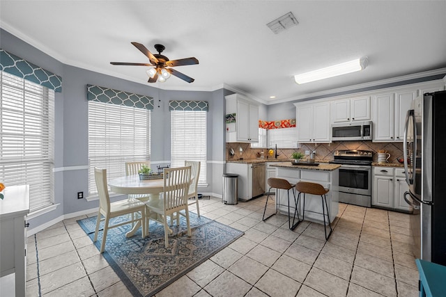 209 Keswick Dr, Hewitt, TX 76643 - kitchen with stainless steel appliances, a sink, backsplash, a center island, and ceiling fan