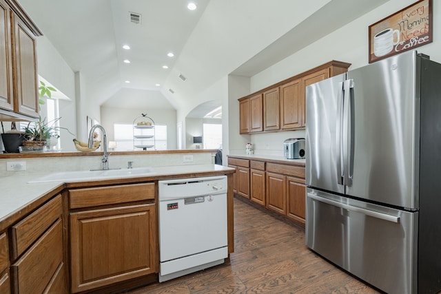 1415 Clubhill Dr, Rockwall, TX 75087 - kitchen featuring freestanding refrigerator, white dishwasher, lofted ceiling, brown cabinetry, and dark wood-style floors