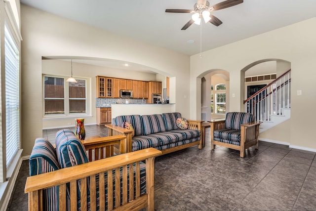 12816 Lizzie Pl, Fort Worth, TX 76244 - living room featuring a ceiling fan, arched walkways, baseboards, and stairs